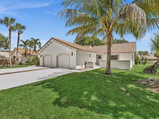Stucco exterior with a tile roof, two-car garage, and a concrete driveway