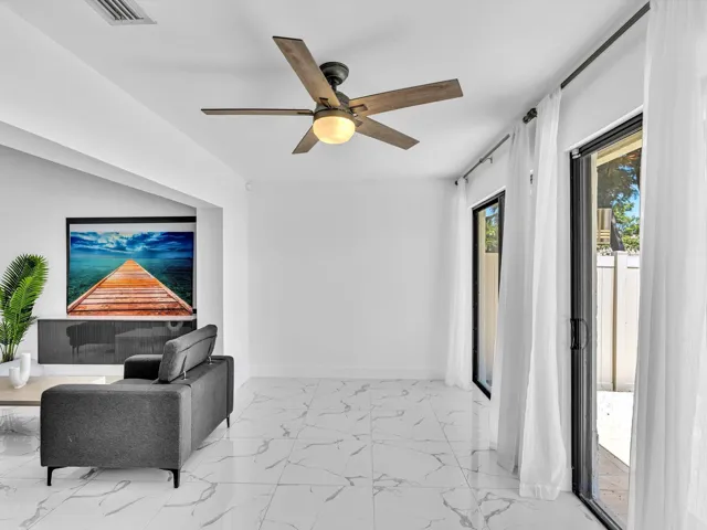 White tile flooring, recessed lighting, ceiling fan, and sliding glass doors