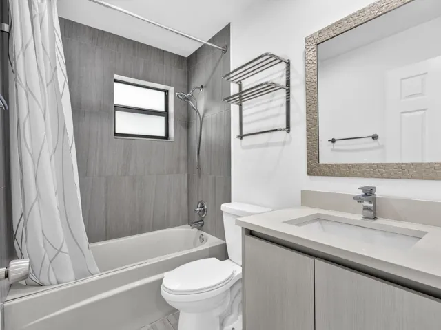 Bathroom featuring a single vanity with a light-toned countertop, an integrated sink, and an undermount cabinet