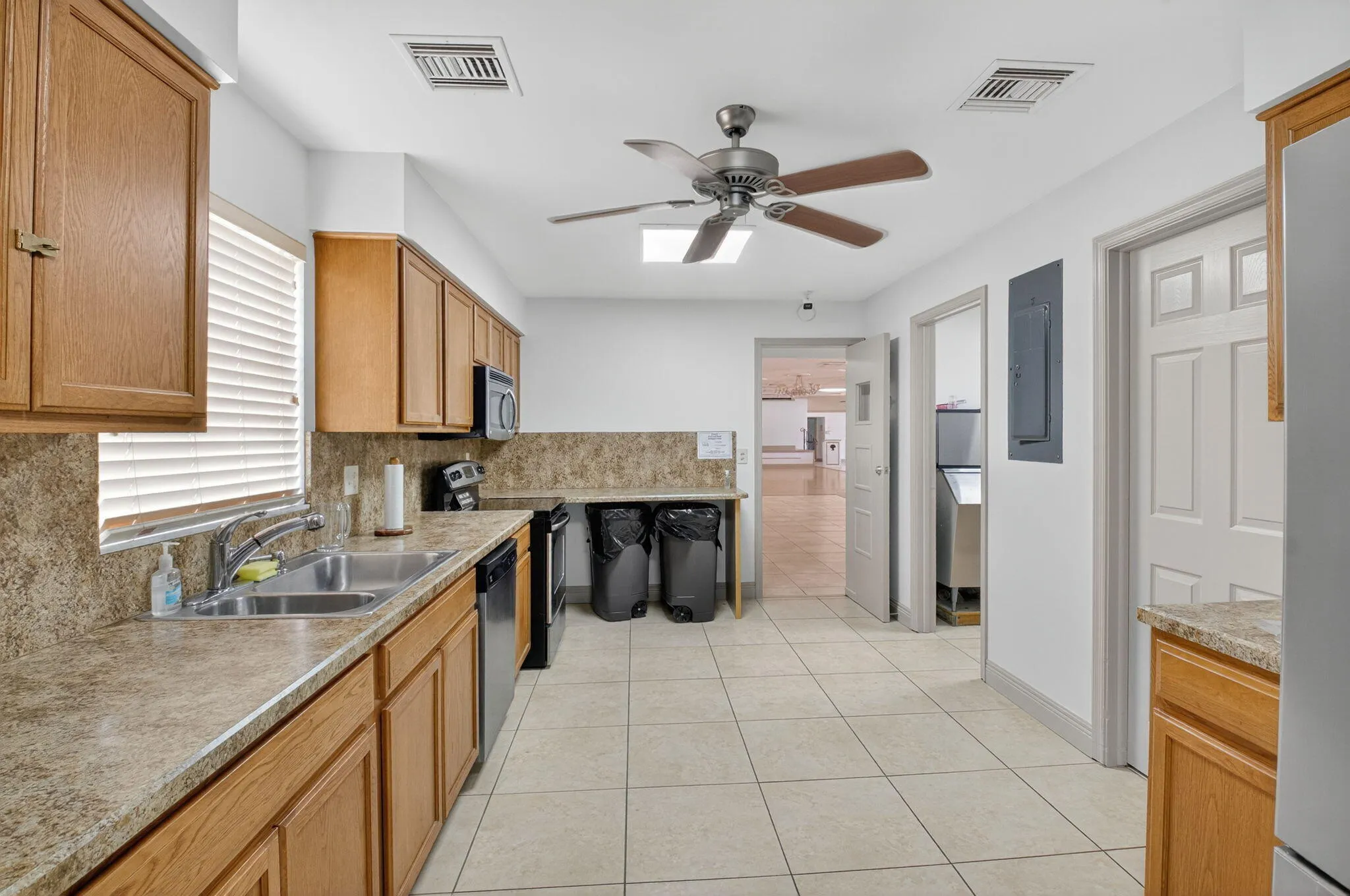 Wood-finish cabinetry, tile flooring, and a double basin sink