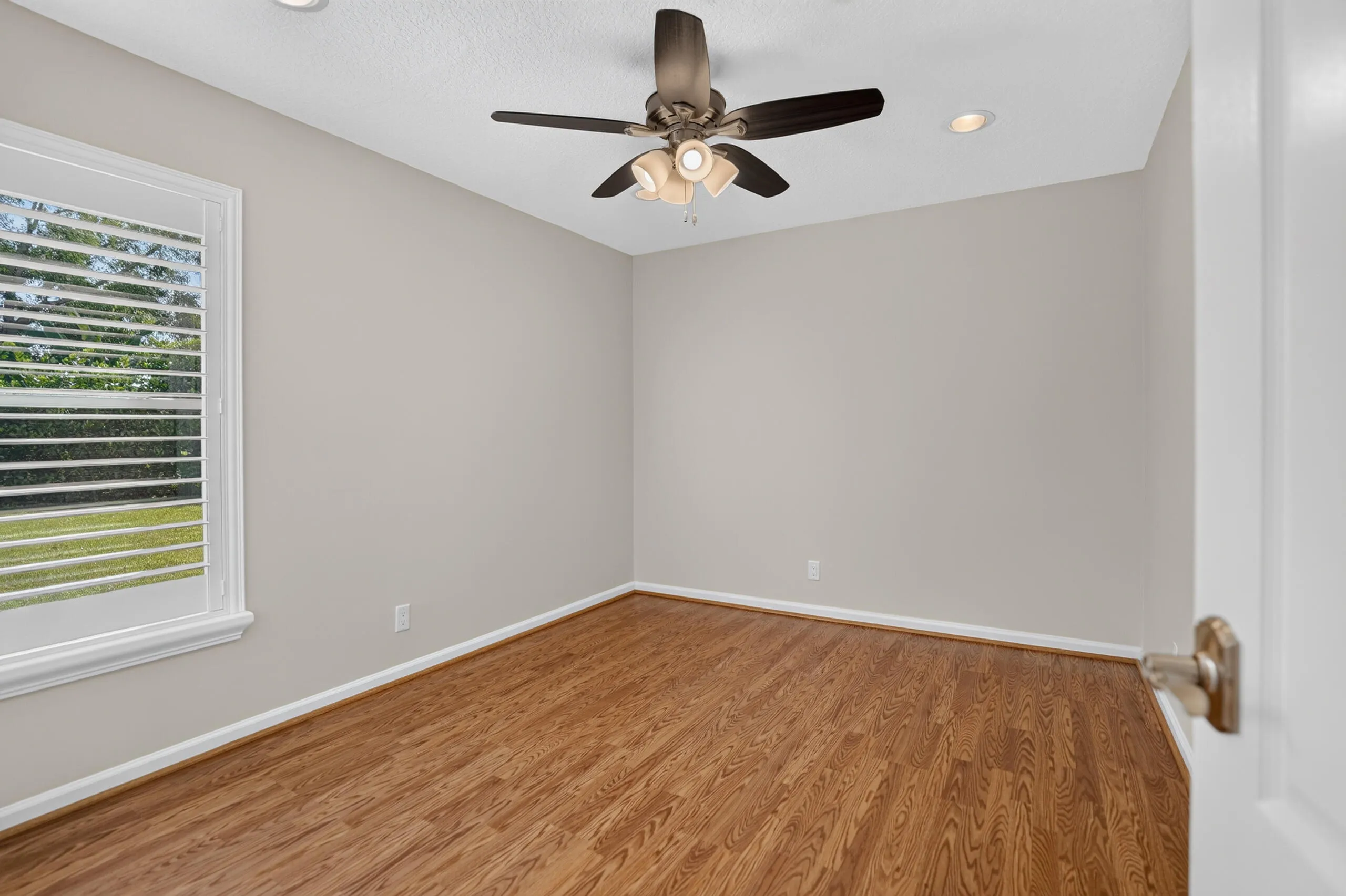 Wood-finish flooring, recessed lighting, and a ceiling fan with integrated light fixture