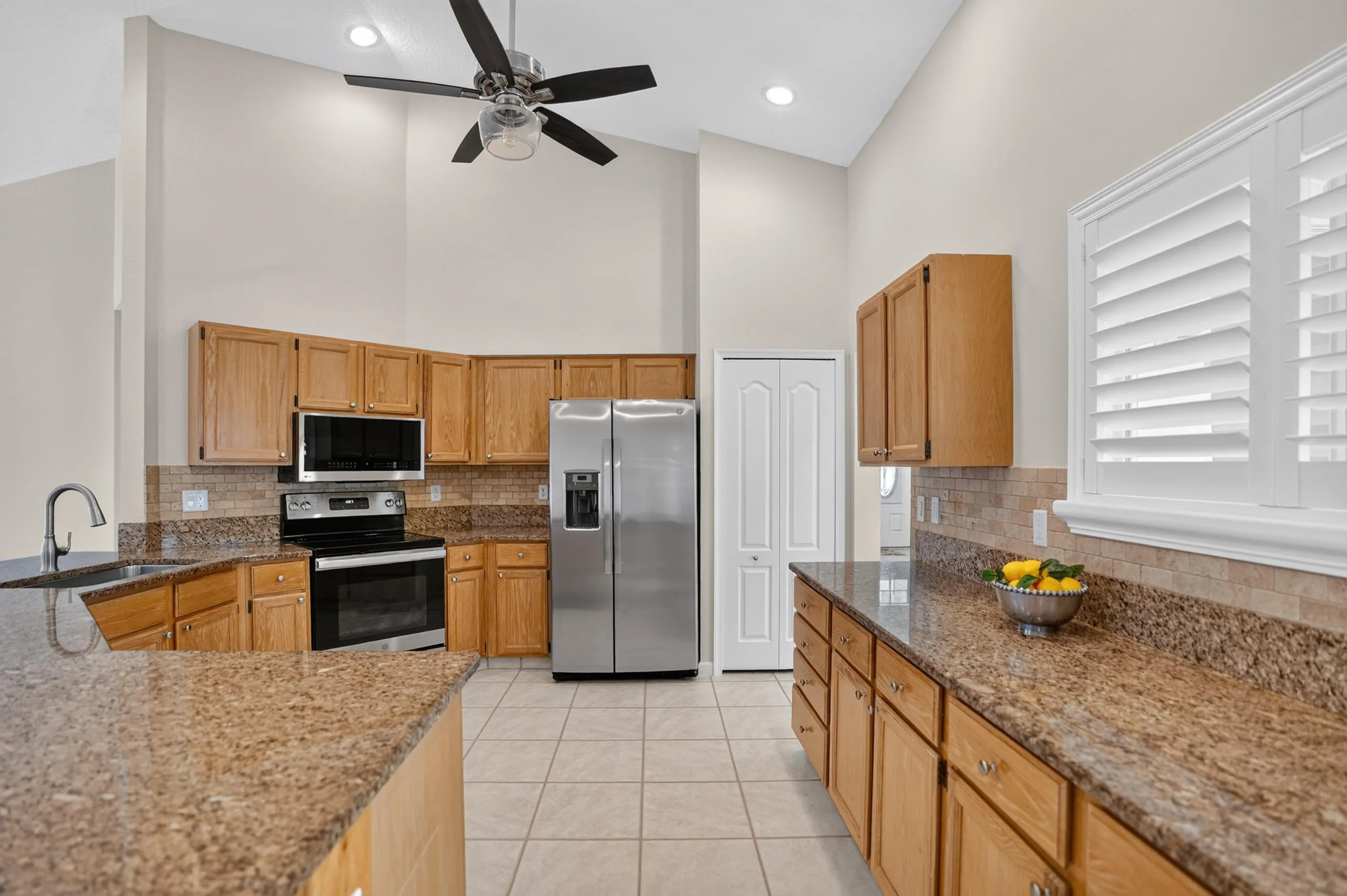 Vaulted ceilings, wood cabinetry, granite countertops, tile flooring, and stainless steel appliances