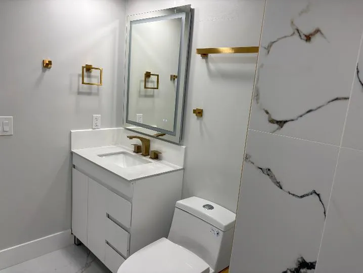 White vanity with integrated sink and gold-finish faucet