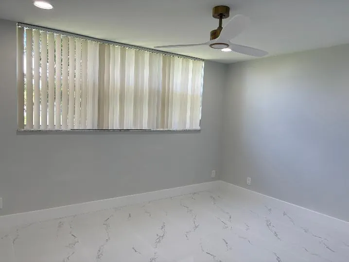 Recessed ceiling lighting, ceiling fan with integrated lighting, light-toned walls, and large format tile flooring