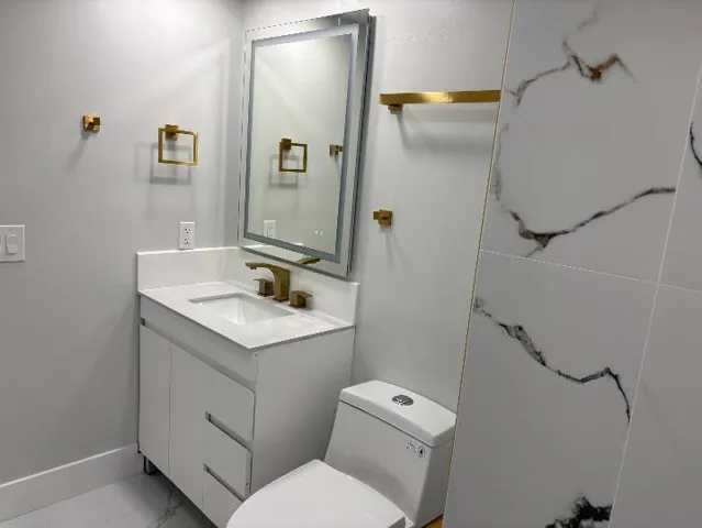 White vanity with integrated sink and gold-finish faucet