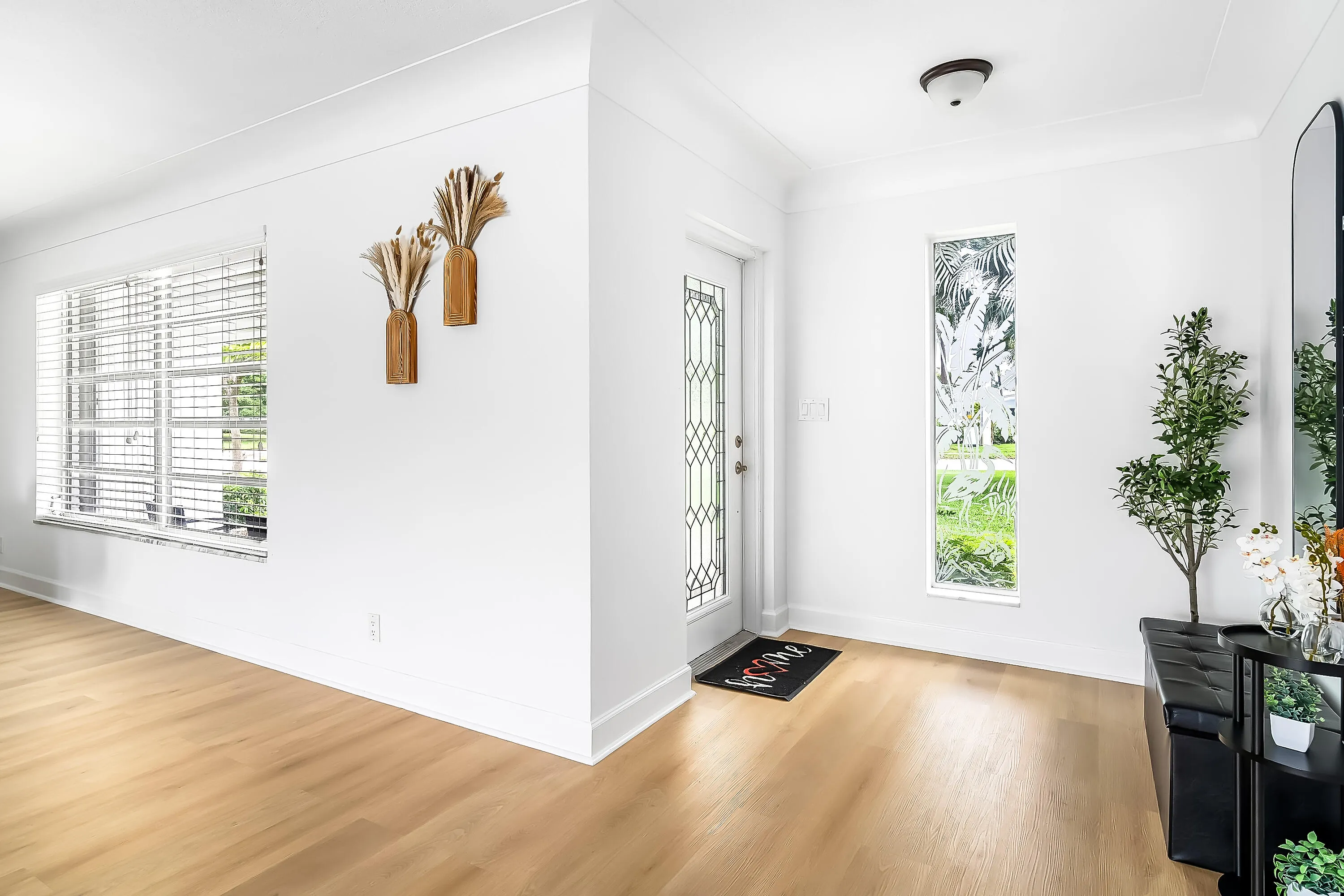 Entryway featuring a decorative glass panel door, light wood-finish flooring, a rectangular vertical window, crisp white walls, and crown molding