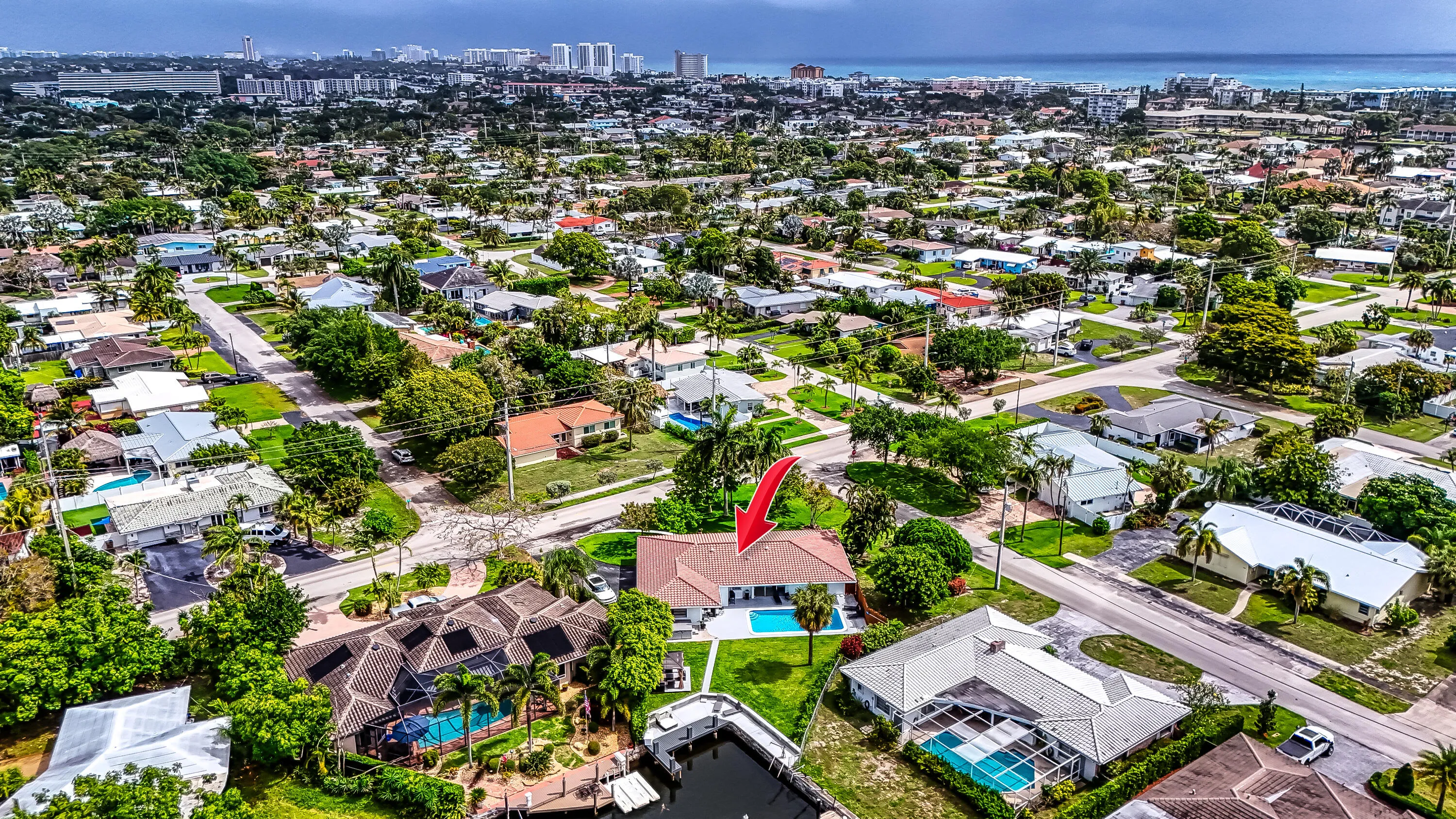 Aerial perspective of a residential neighborhood featuring a property with a private pool