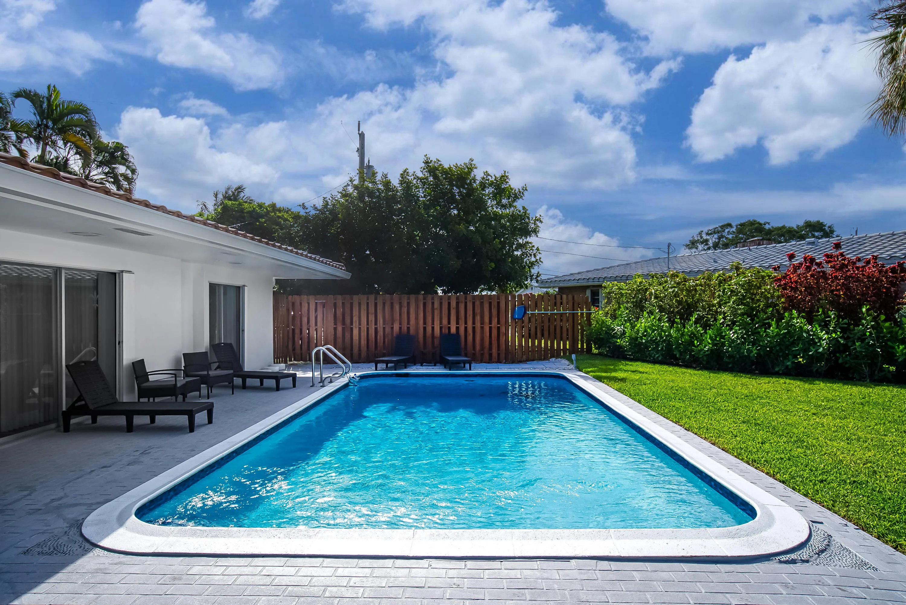 Rectangular swimming pool with integrated steps and a surrounding paver patio