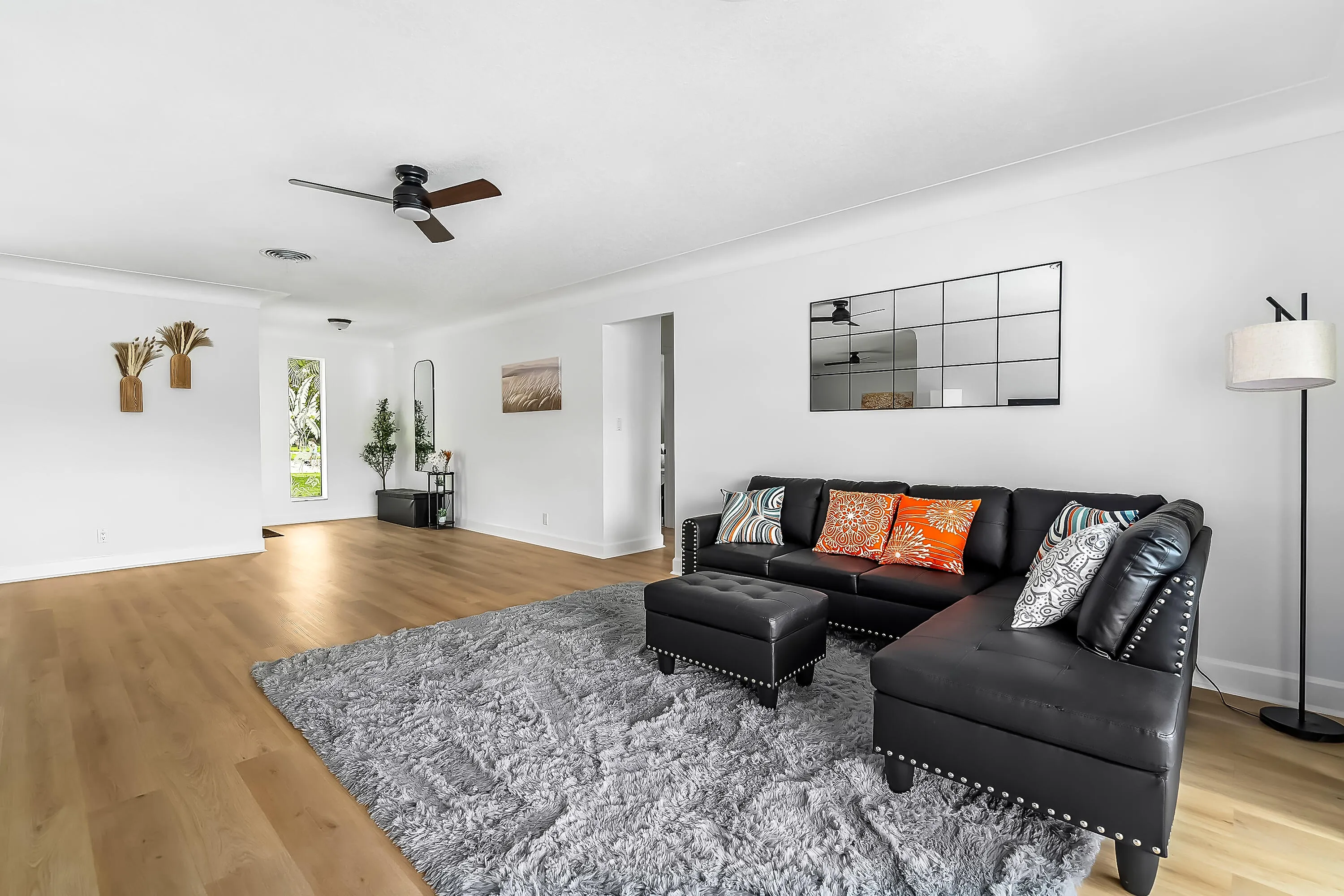 Expansive living area featuring light wood-finish flooring, white walls, and crown molding