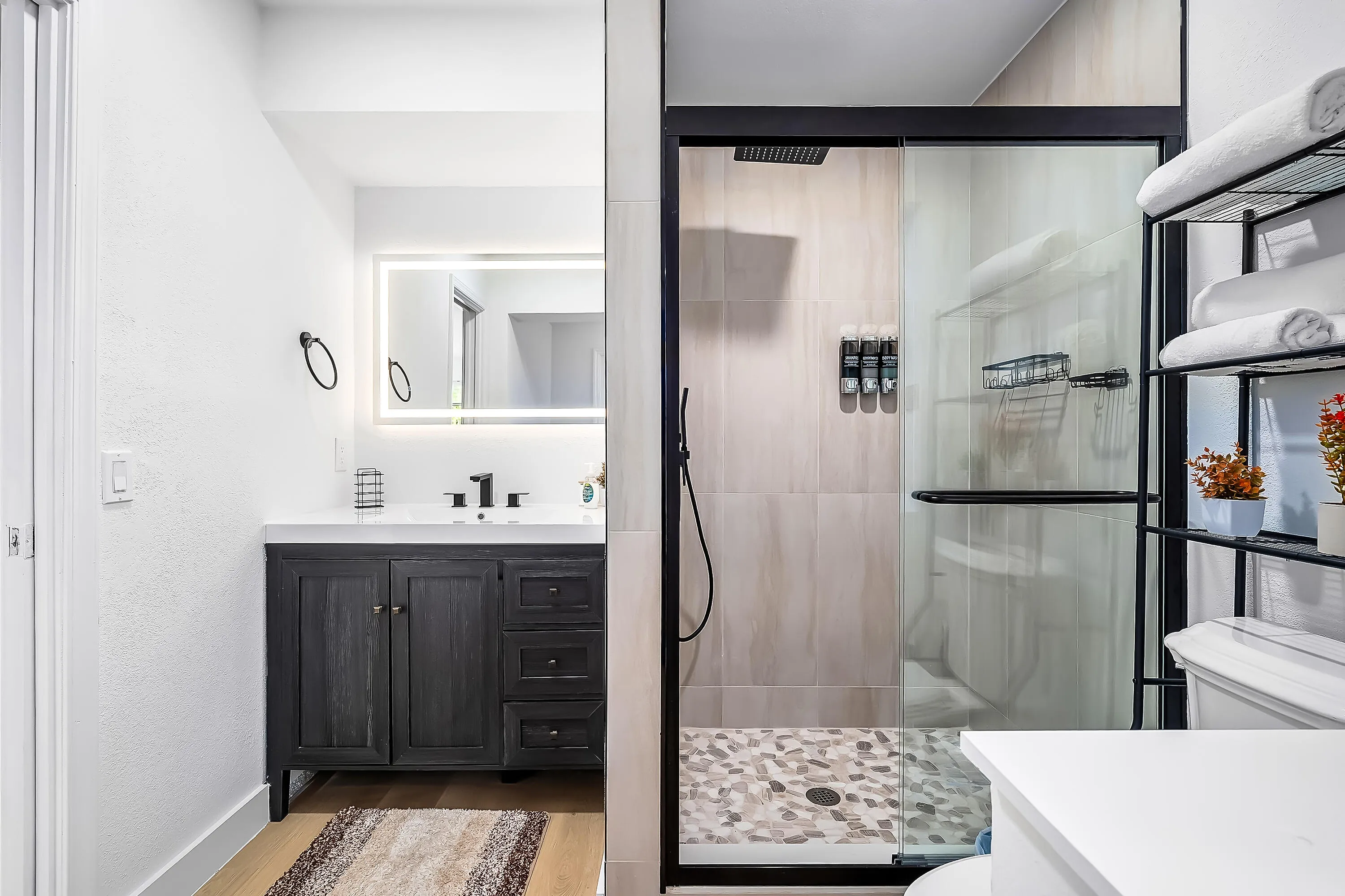 Modern bathroom featuring a dark wood-finish vanity with a white countertop and rectangular sink