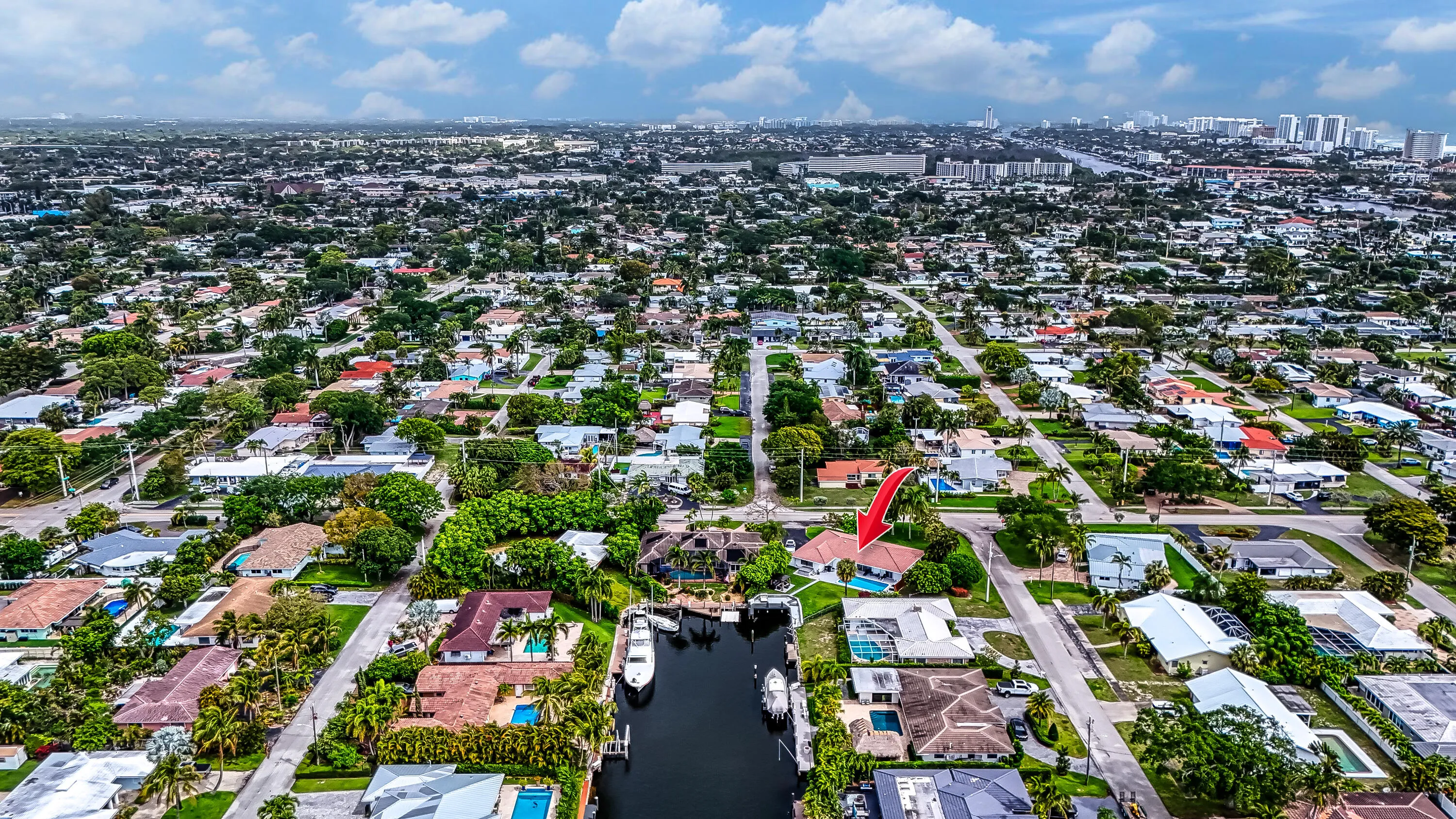 Waterfront property featuring a private boat dock, mature landscaping, and a swimming pool