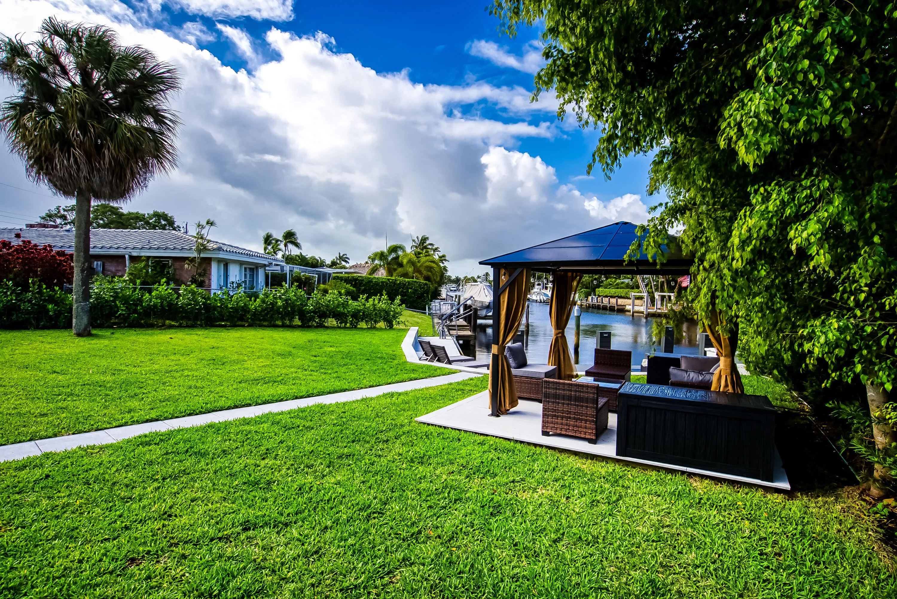 Waterside gazebo on a concrete patio with perimeter landscaping