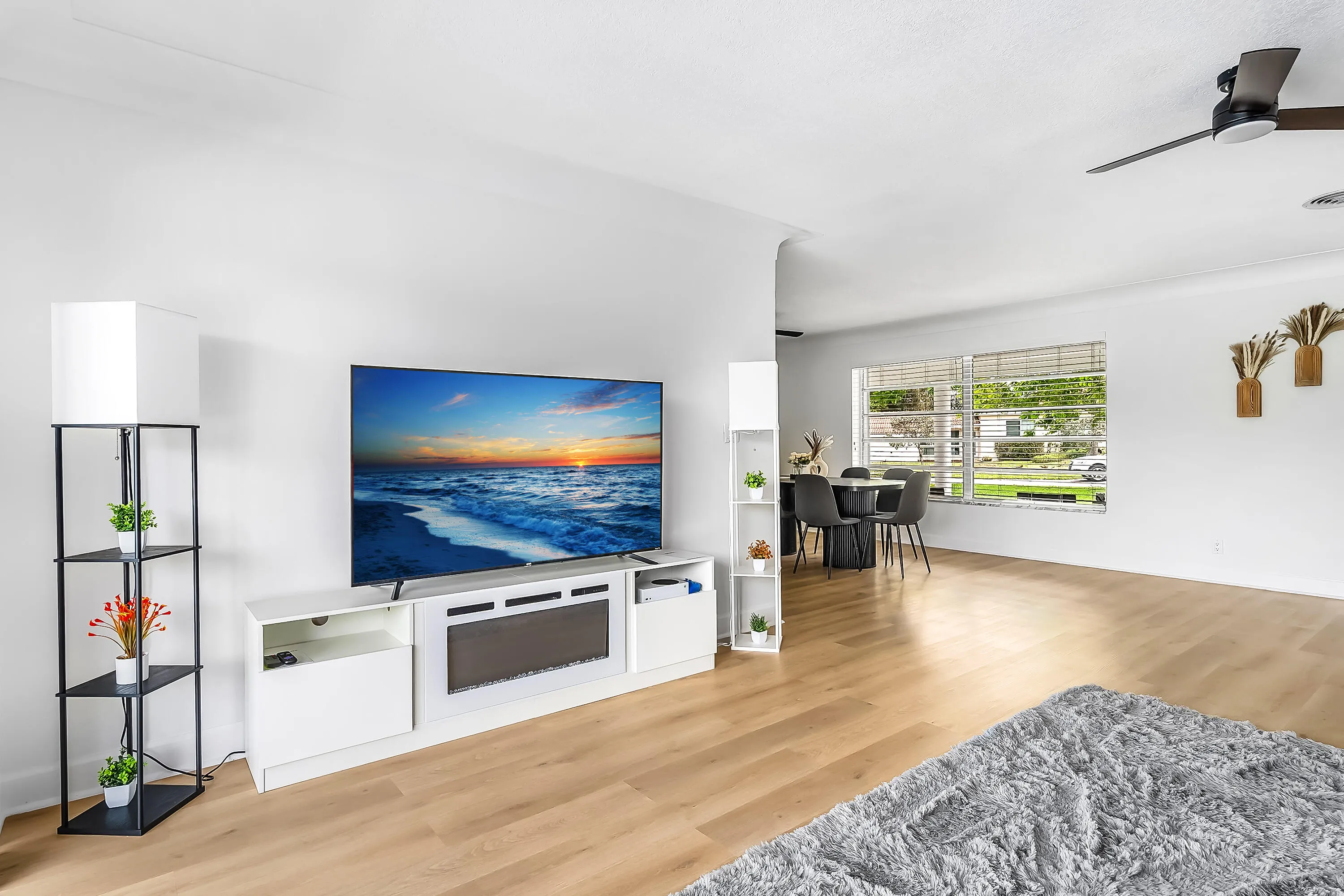 Bright interior featuring wood-finish flooring, white walls, and a contemporary ceiling fan