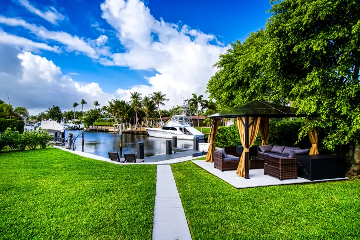 Manicured green lawn with a waterside dock featuring multiple boat slips
