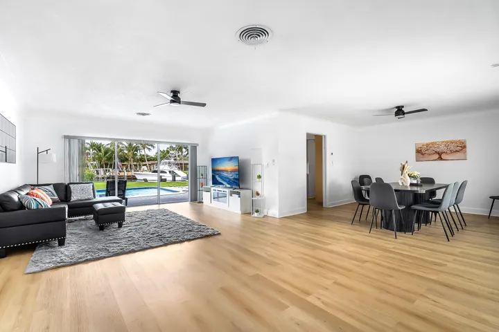 Expansive living area with light wood-finish flooring extending into the dining space