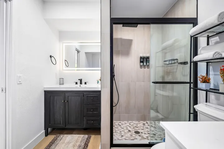 Modern bathroom featuring a dark wood-finish vanity with a white countertop and rectangular sink
