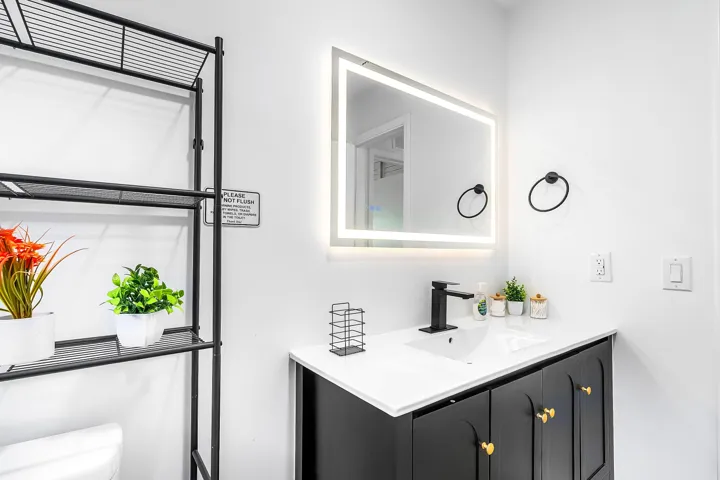 Modern bathroom vanity featuring a white countertop, undermount sink, and matte black faucet