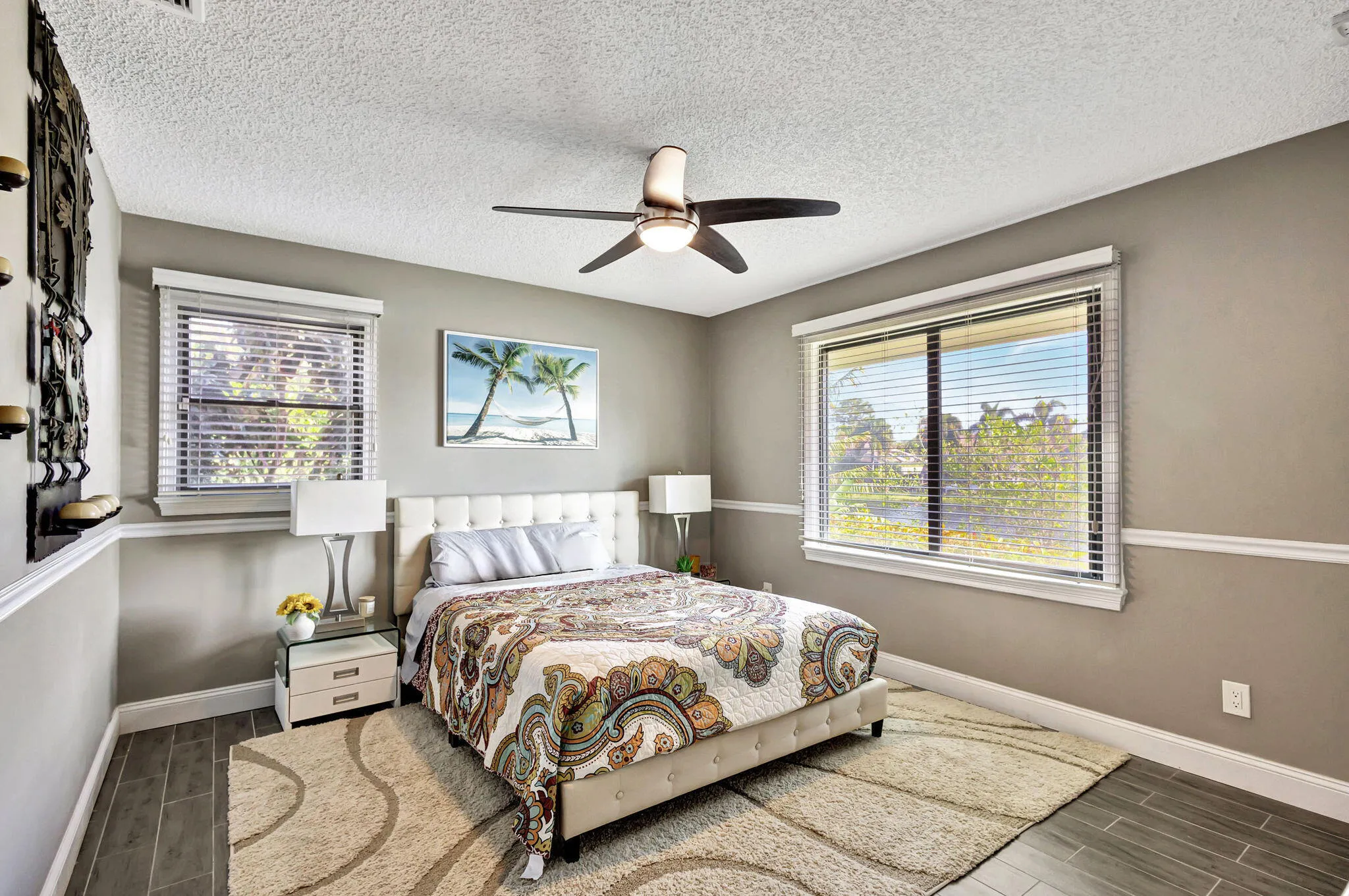 Wood-finish flooring, ceiling fan, multiple windows, and crown molding