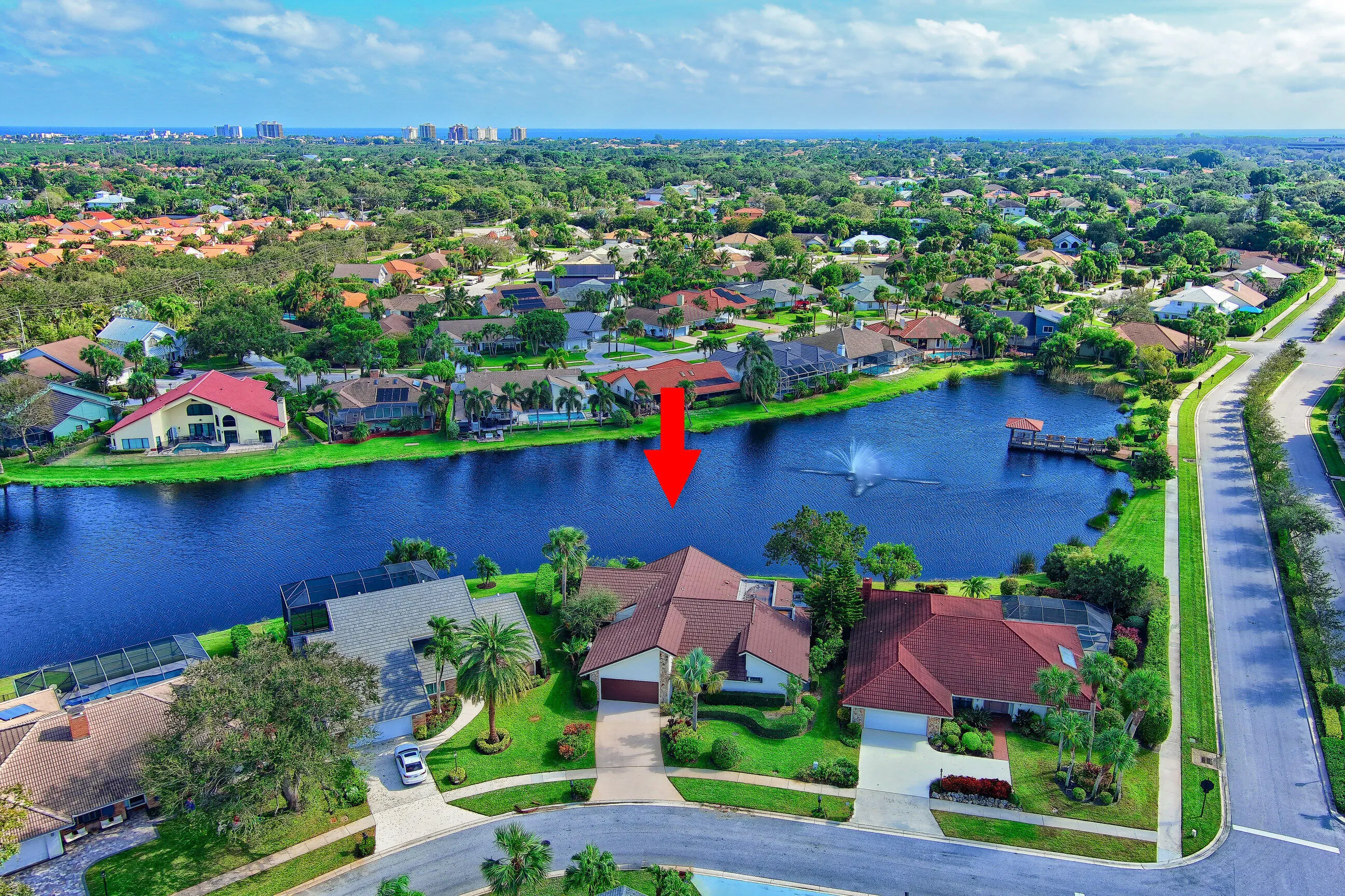 Lakeside property featuring a cul-de-sac location, paved driveway, and mature landscaping