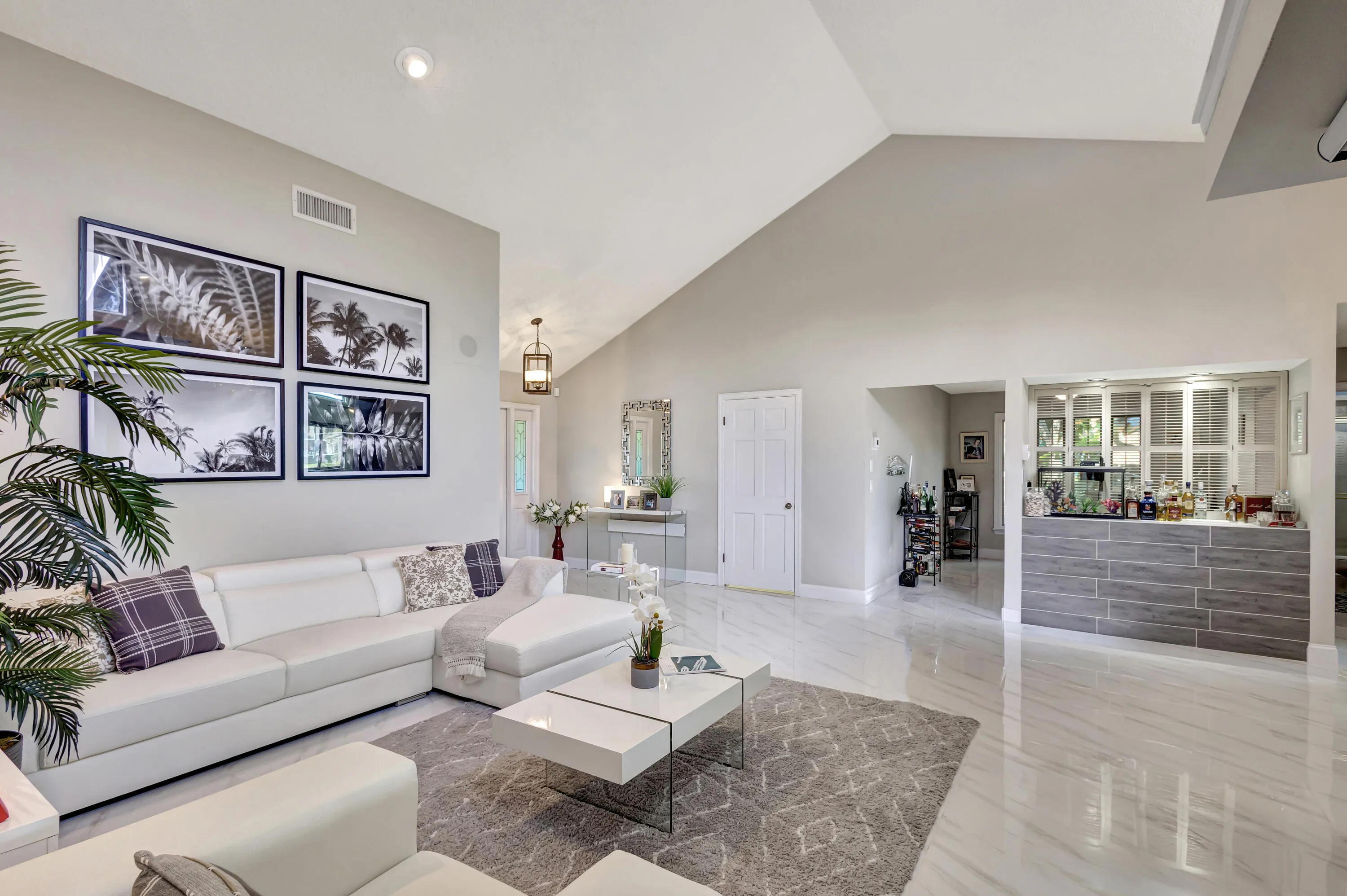 Vaulted ceiling, recessed lighting, tile flooring, built-in bar, and a paneled white door