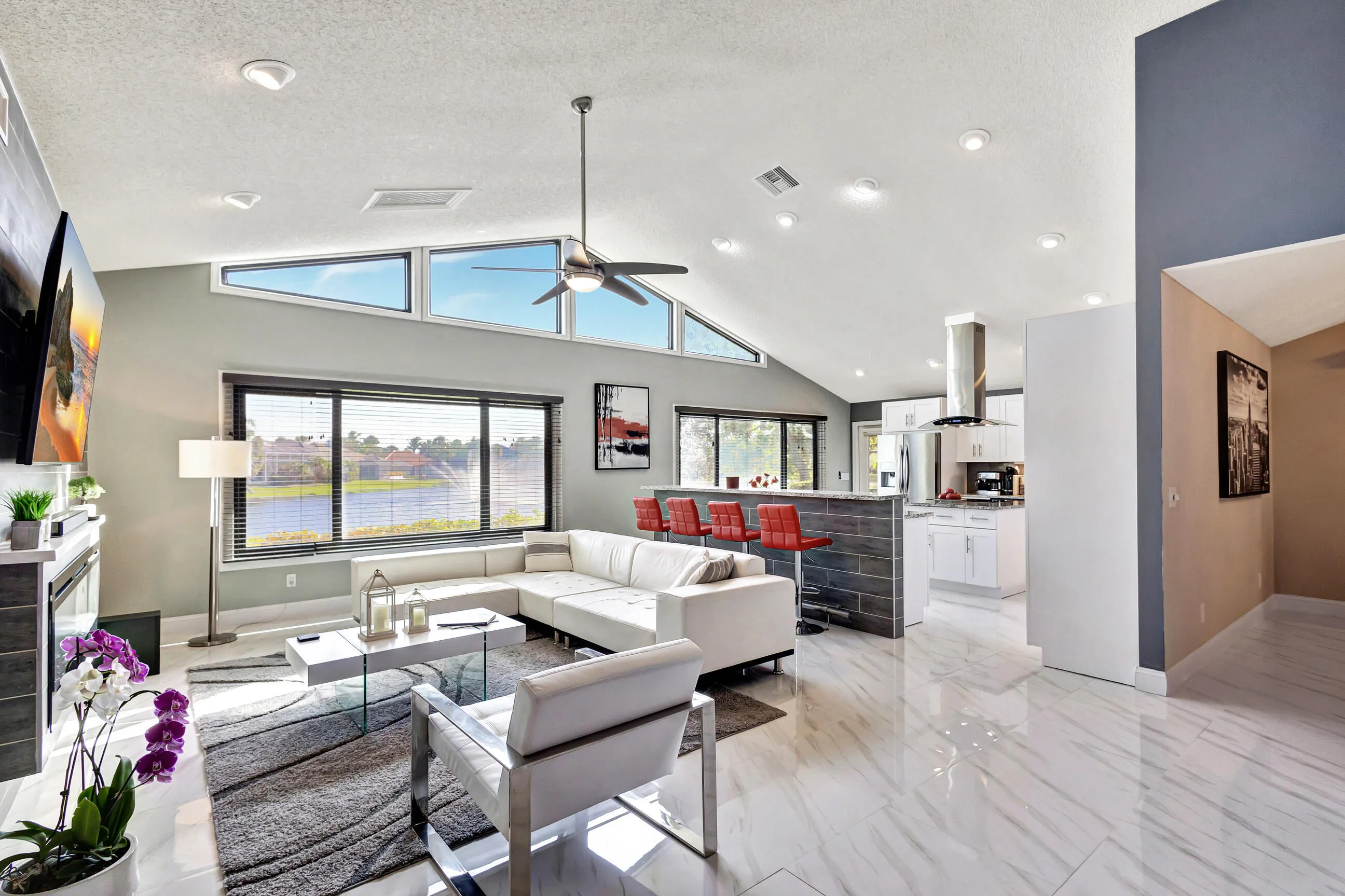 Vaulted ceiling with a ceiling fan, recessed lighting, and high-set windows
