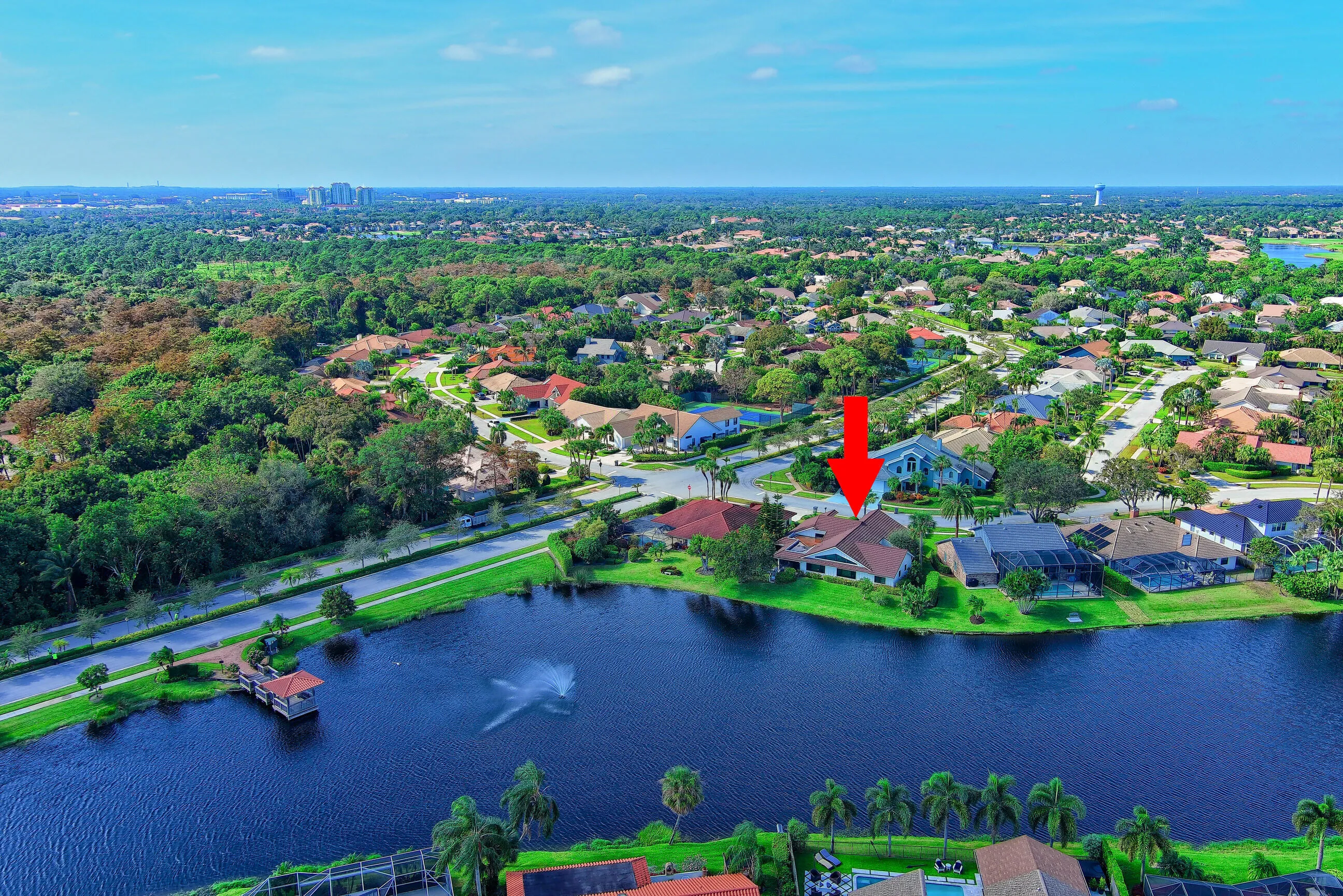 Waterfront property with a private dock, lush landscaping, and a tile roof