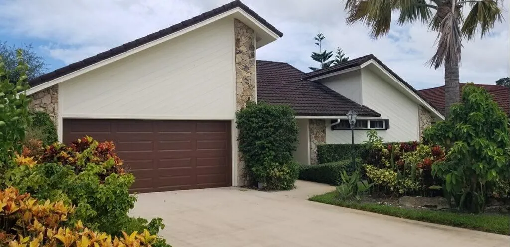Single-story residence featuring a brown panel garage door and a concrete driveway