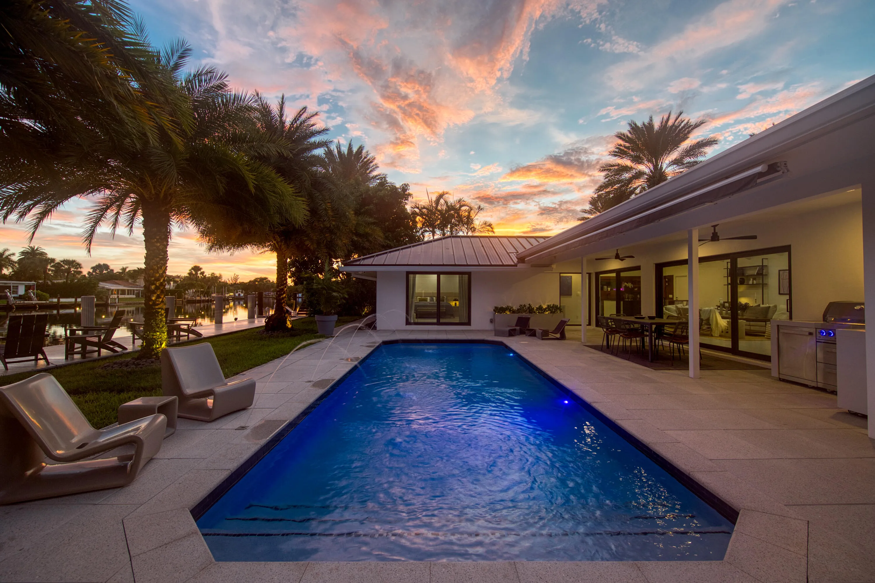 The pool, waterfront and patio at twighlight