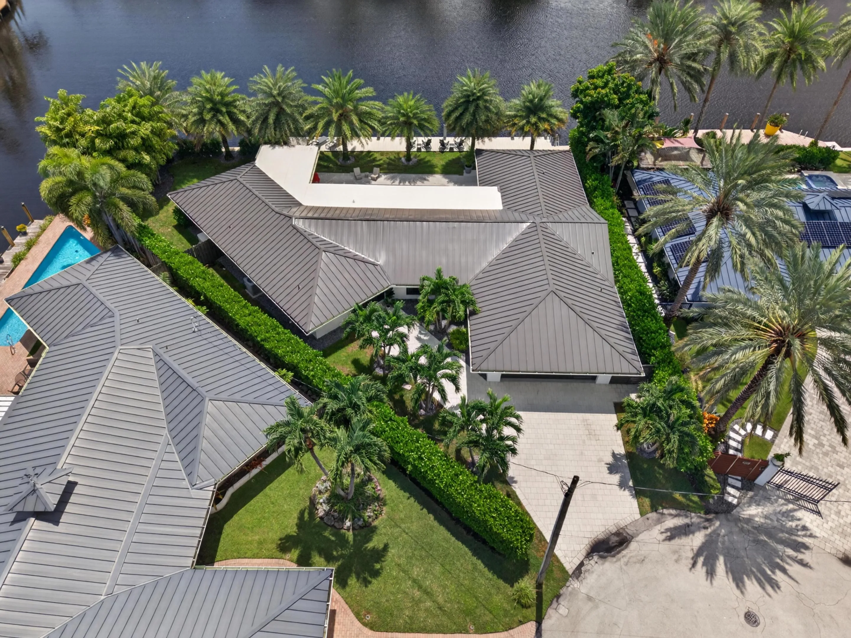 Aerial view if home with metal roof and tropical landscaping