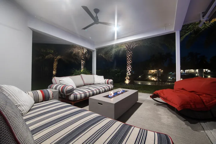 Outdoor kitchen with fire pit at night overlooks waterfront