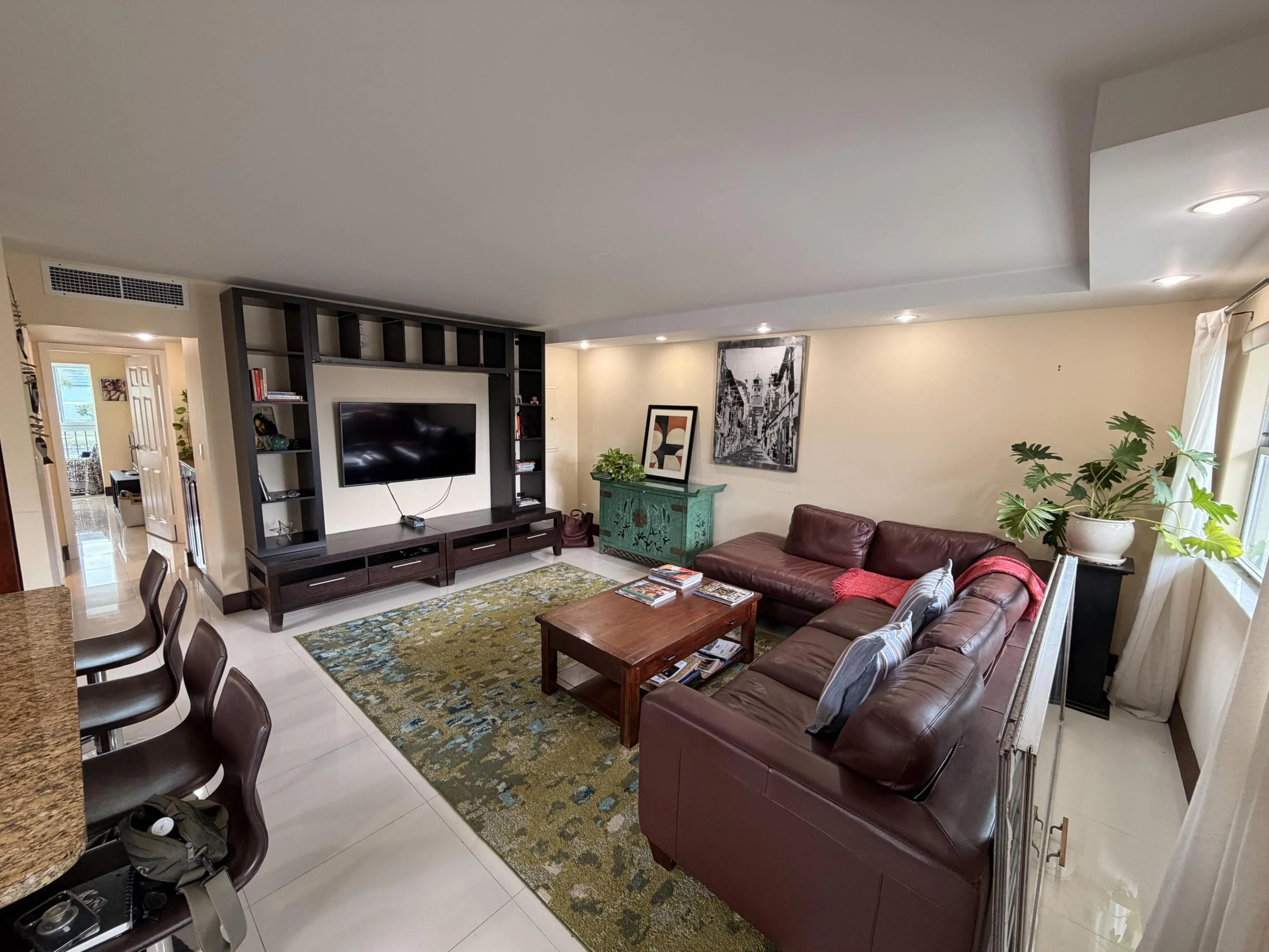 Recessed lighting, light-toned wall finishes, and white tile flooring