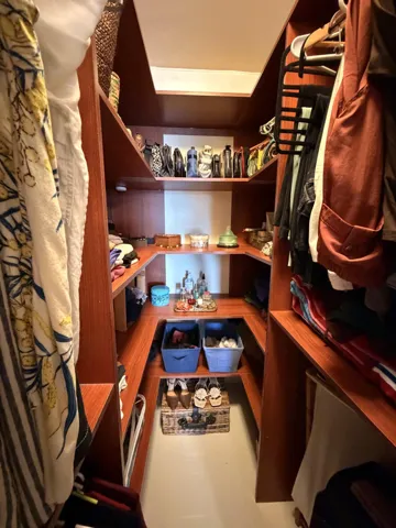 Built-in wood-finish shelving with multiple levels of storage and hanging rods