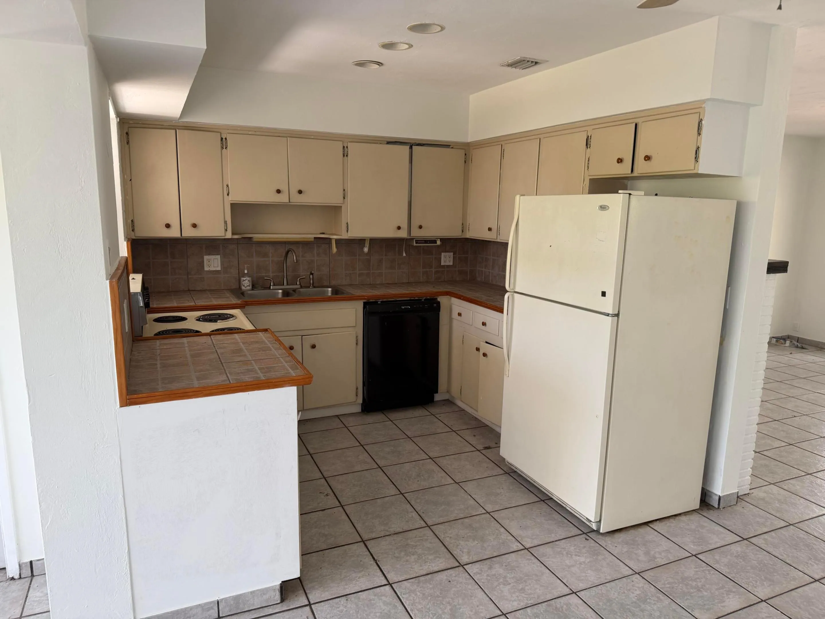 U-shaped kitchen featuring tile countertops, a tile backsplash, recessed lighting, and tile flooring