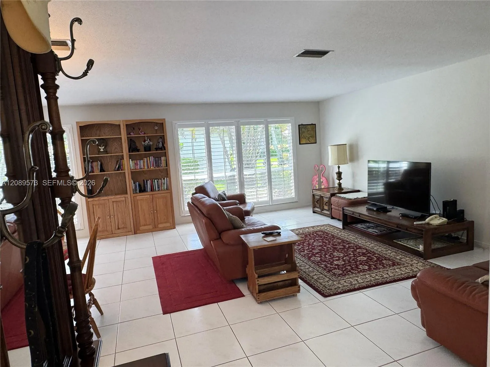 Large living room (view from foyer). Beautiful large windows to rear tastefully decorated with wide blade Plantation shutters to control light and temperature.
