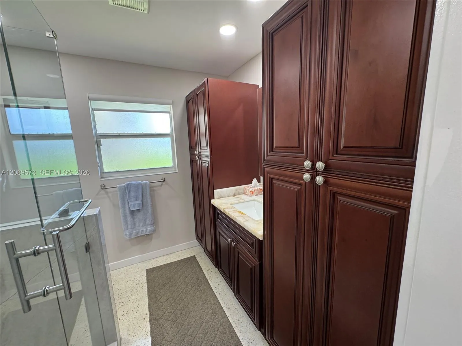 Beautiful custom cabinets in primary bathroom with decorator vanity sink in middle.