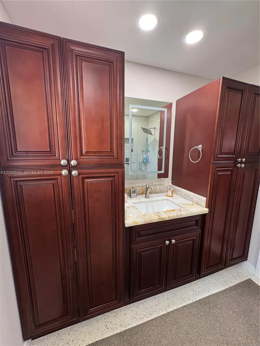 Beautiful custom cabinets in primary bathroom with marble sink vanity.