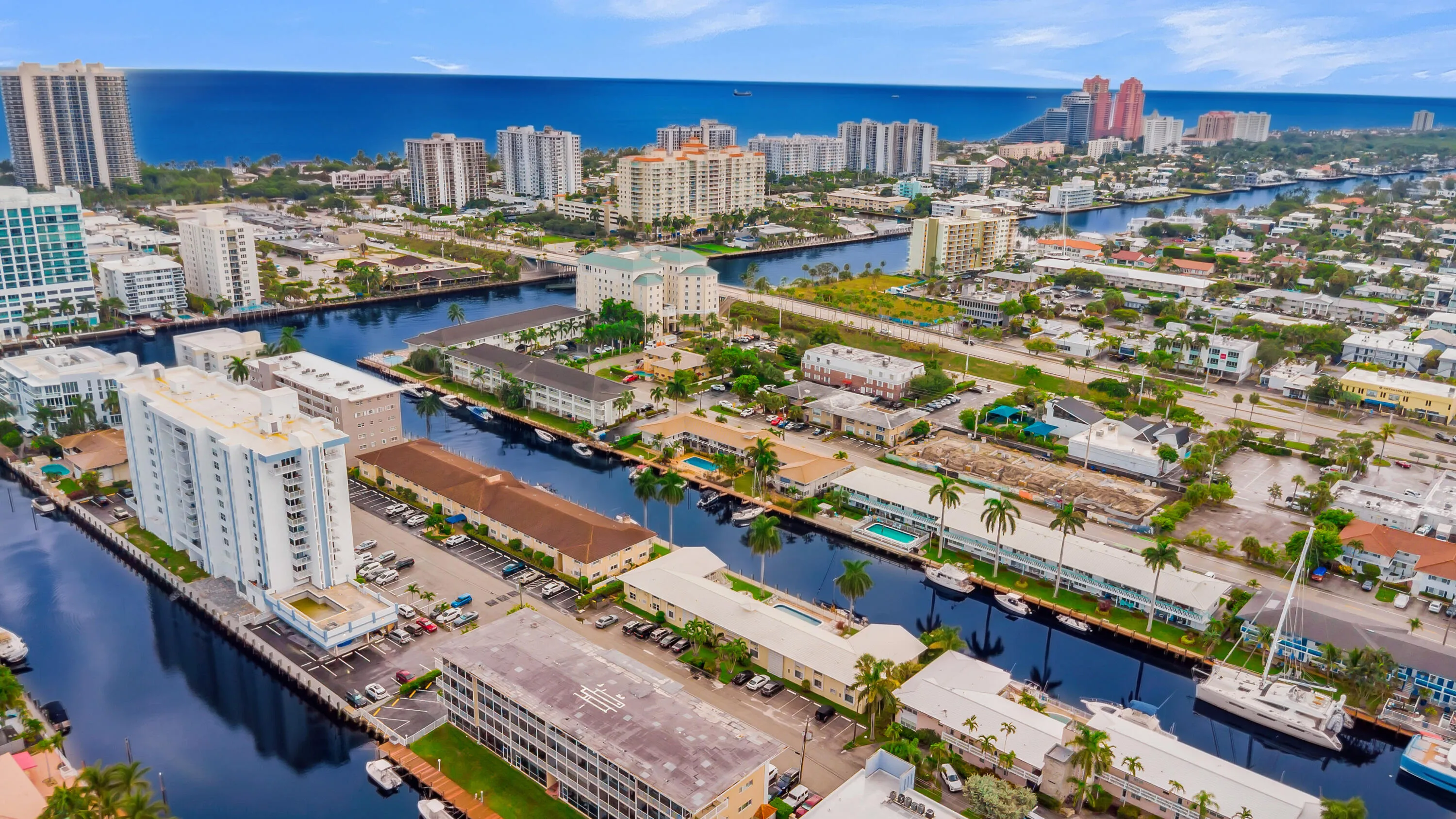 Intercoastal waterway access, multiple high-rise buildings, urban setting, mature palm trees, proximity to ocean