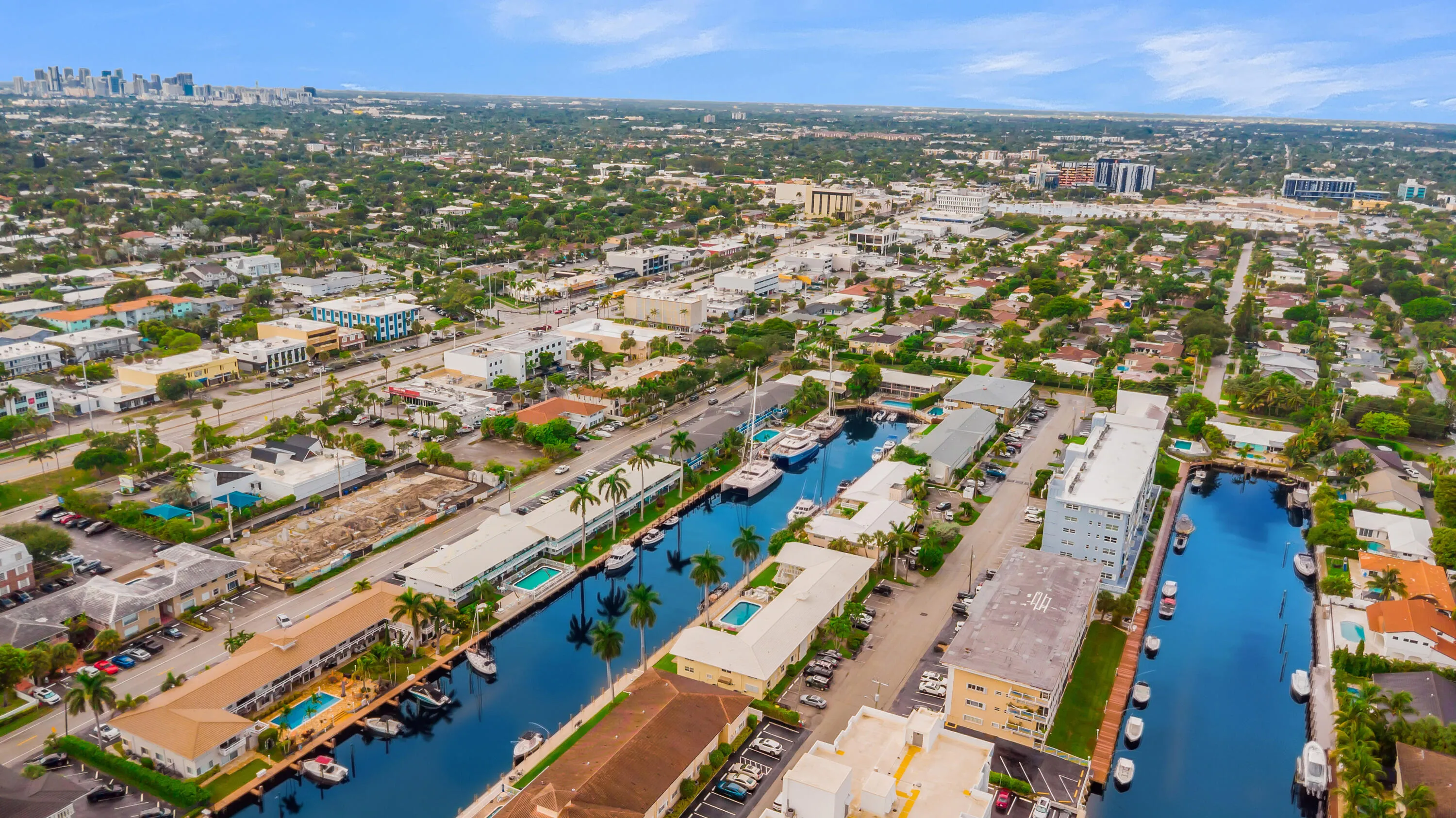 Waterfront properties with direct canal access, established neighborhood with mature trees, and urban skyline in the distance