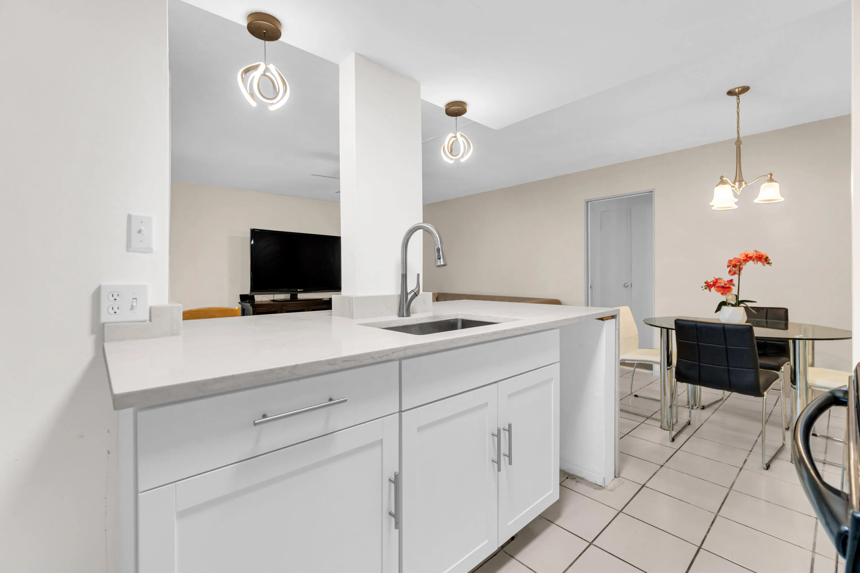 White cabinetry with chrome hardware, an integrated sink, and light-toned countertop