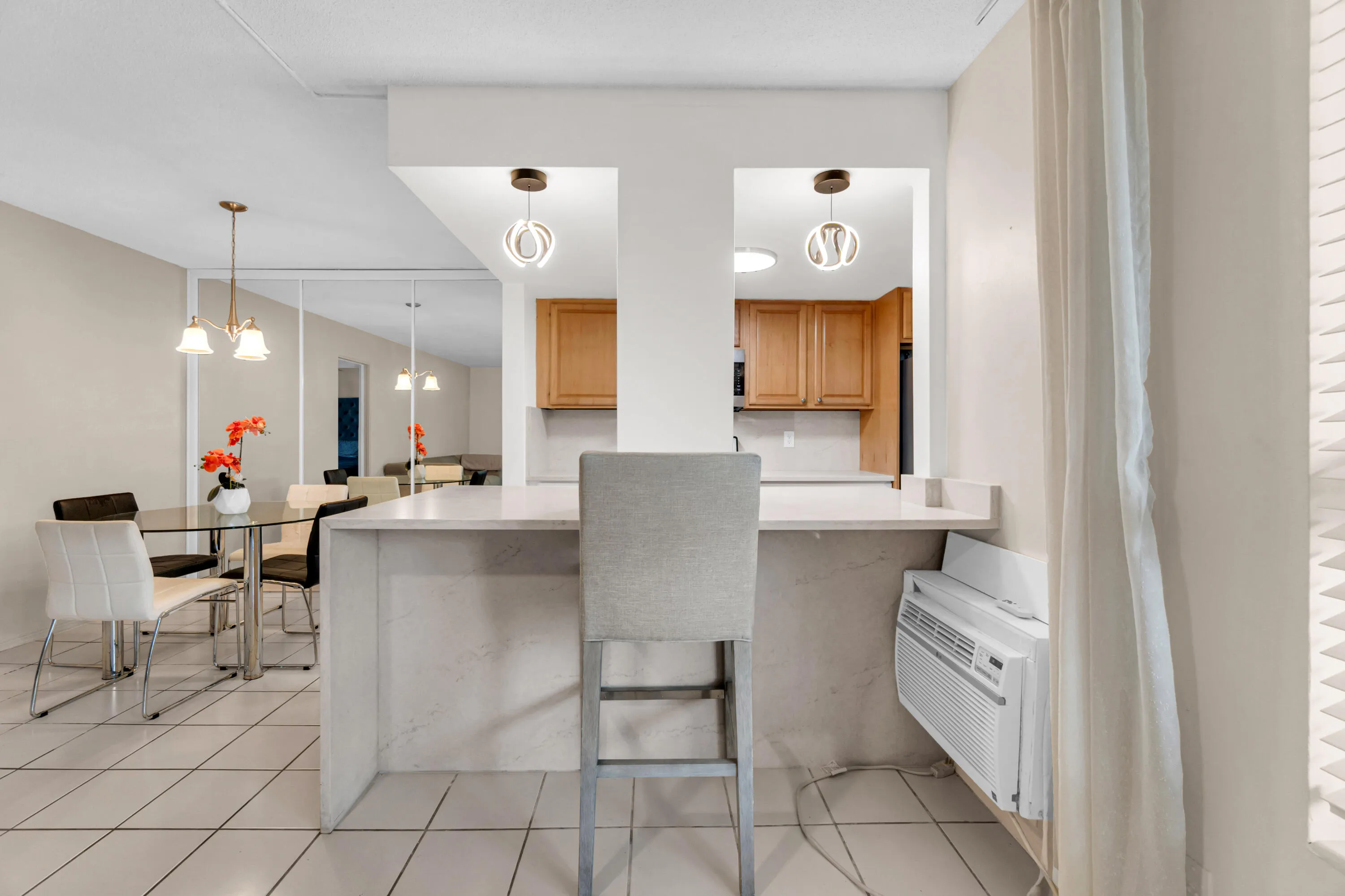 Kitchen pass-through with a breakfast bar and recessed lighting