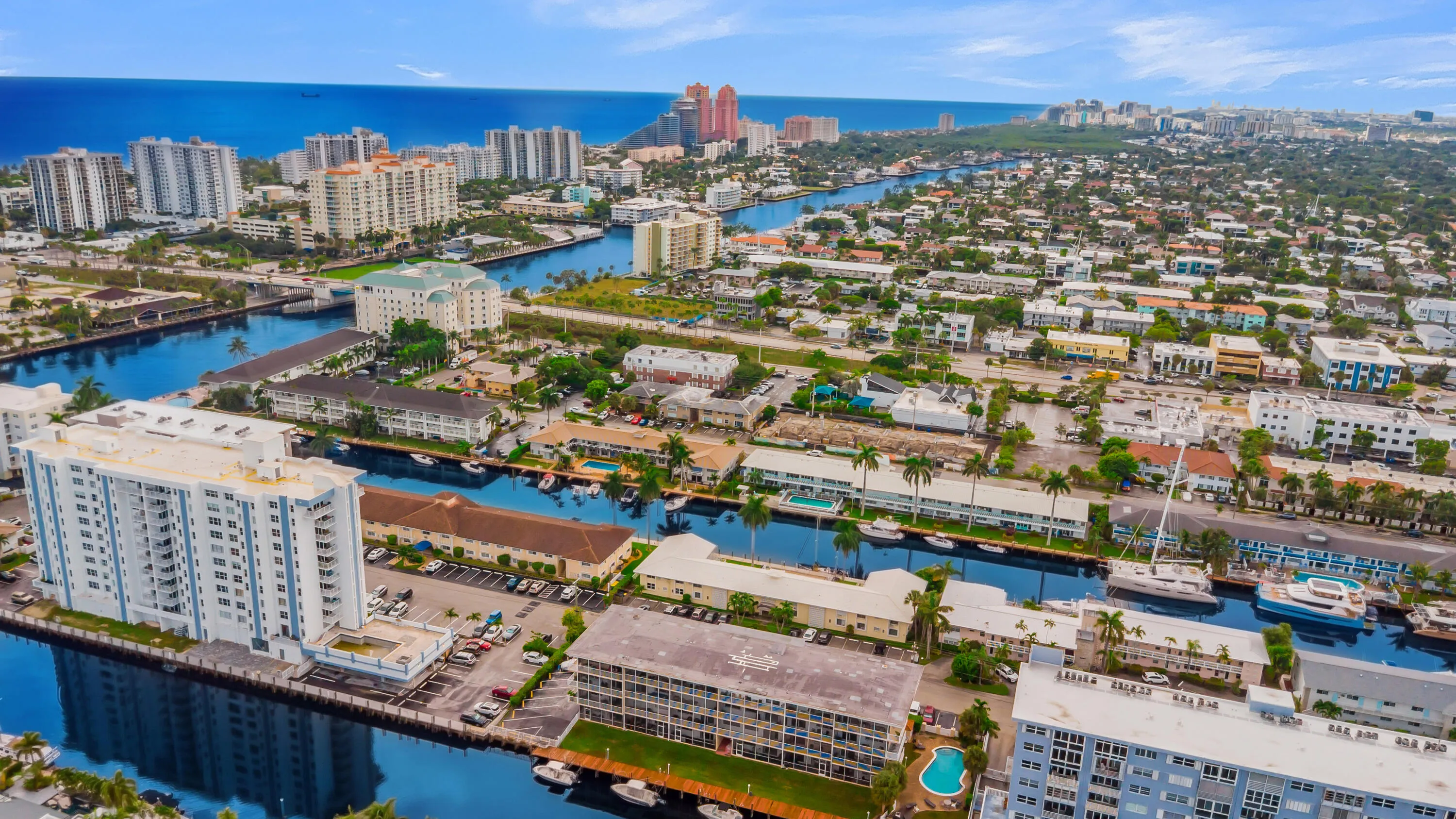 Coastal urban area featuring waterways, dense residential buildings, and scattered green spaces