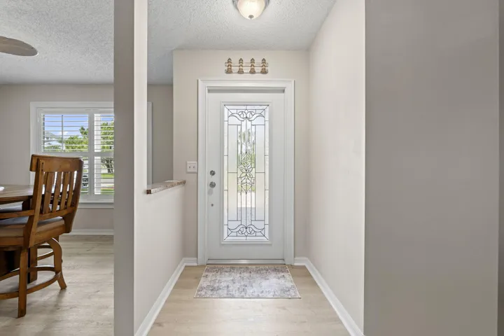 Entryway featuring a decorative glass front door, wood-finish flooring, and a semi-flush mount ceiling light
