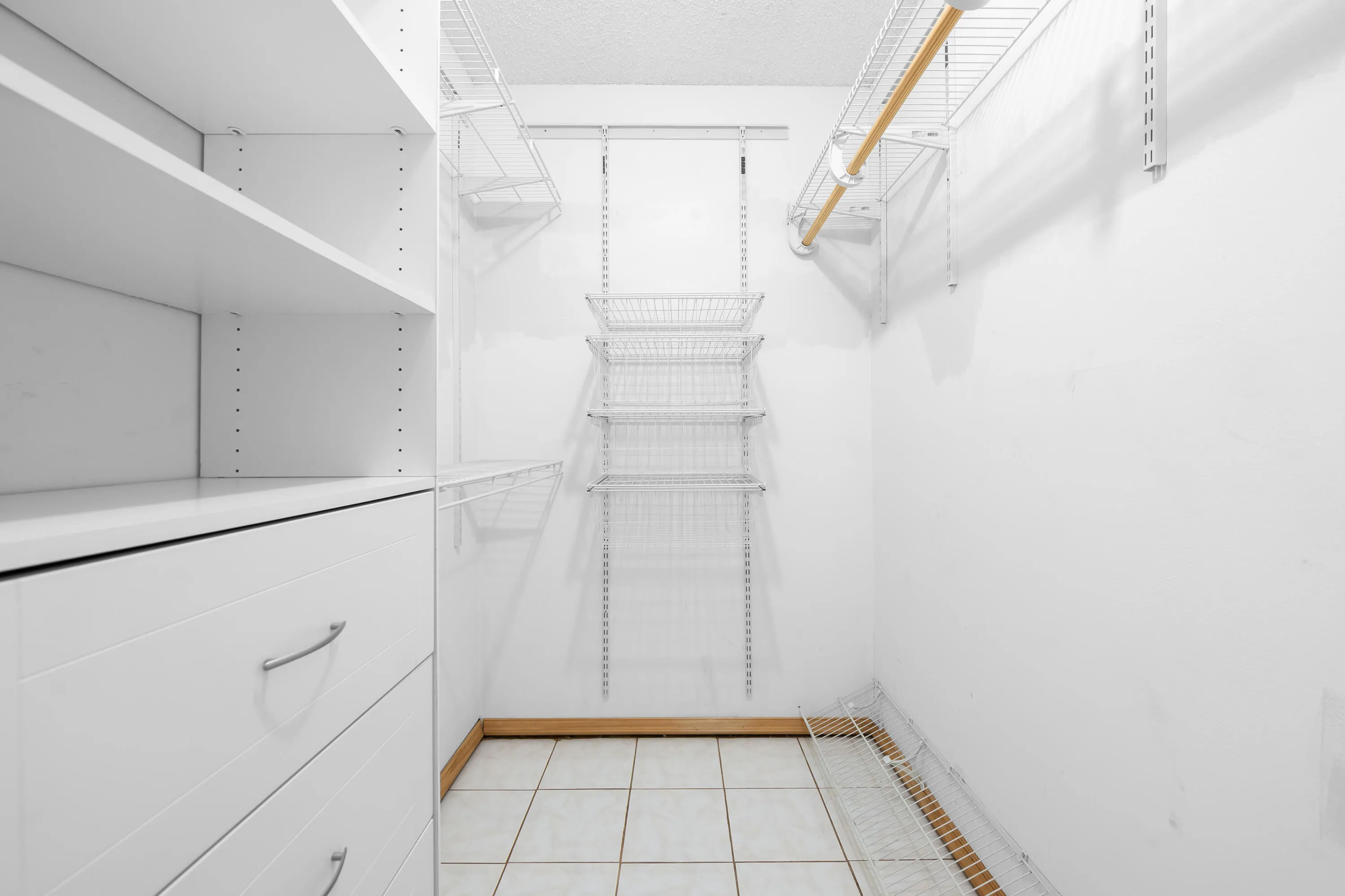 Primary Walk-In Closet with built- in drawers and shelves.