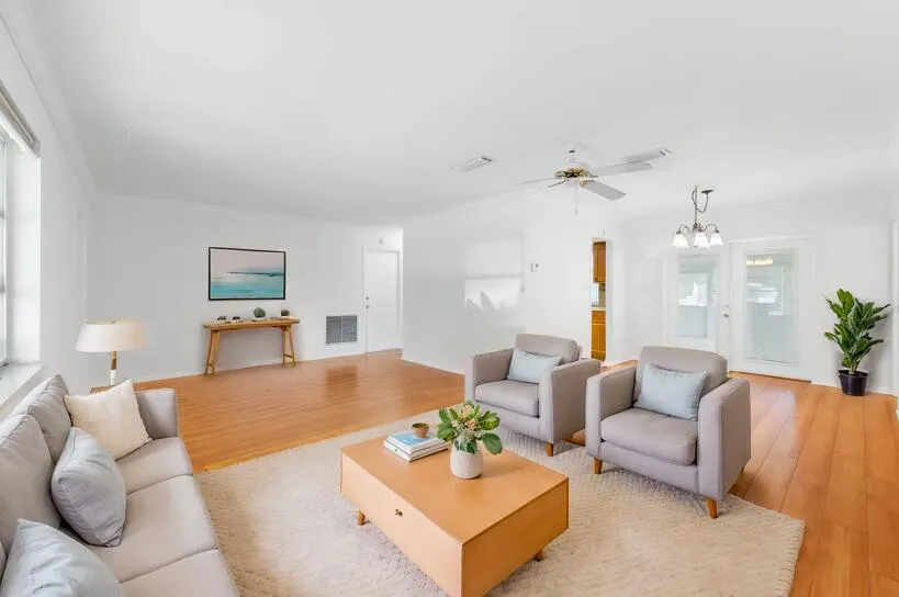 Virtually Staged Photo of the Front Entry and Living Room with additional space that could be used as the dining room or family room.