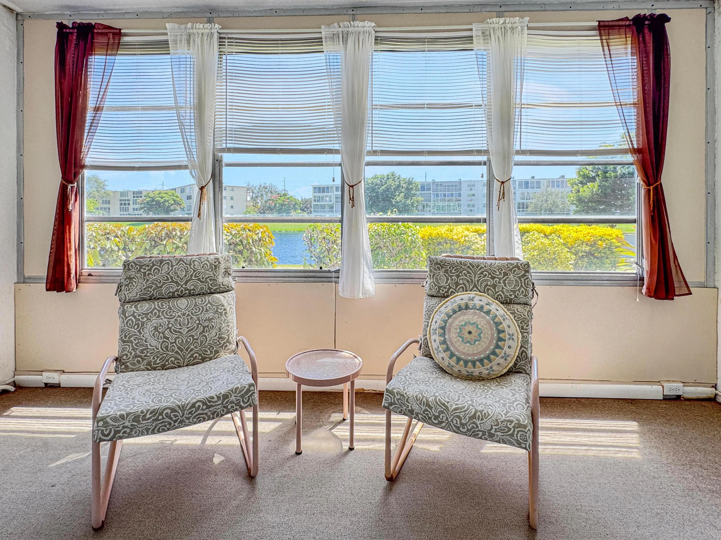 Sunlit room featuring multiple windows with horizontal blinds, providing natural illumination