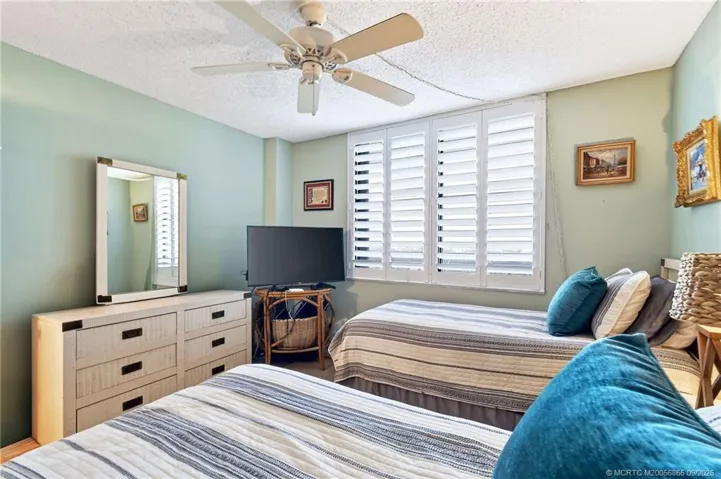 Additional view of the guest bedroom with plantation shutters and ample space for visiting family and friends.