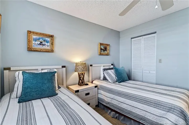 Guest bedroom with twin beds and closet storage.
