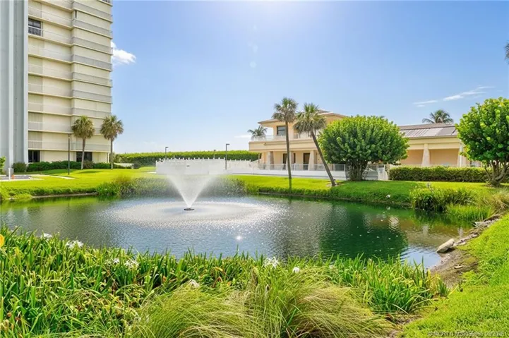 Landscaped community grounds with a tranquil pond and fountain.