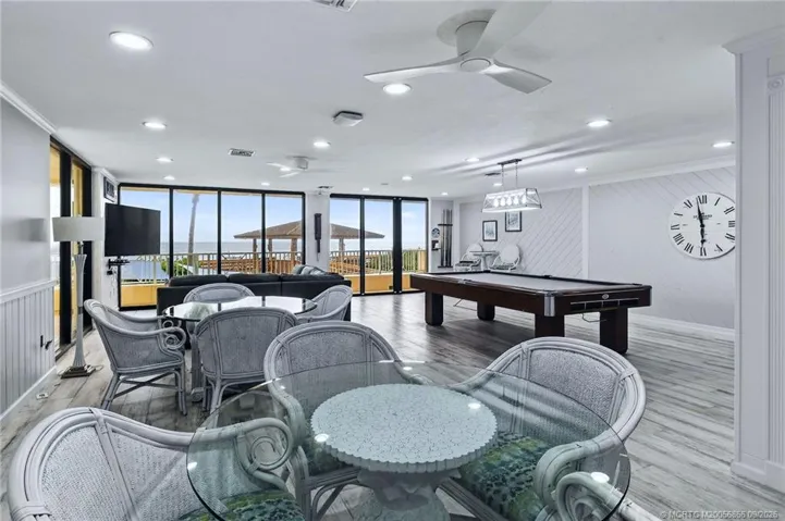 Oceanfront community game room with billiards, multiple seating areas and expansive windows overlooking the Atlantic.