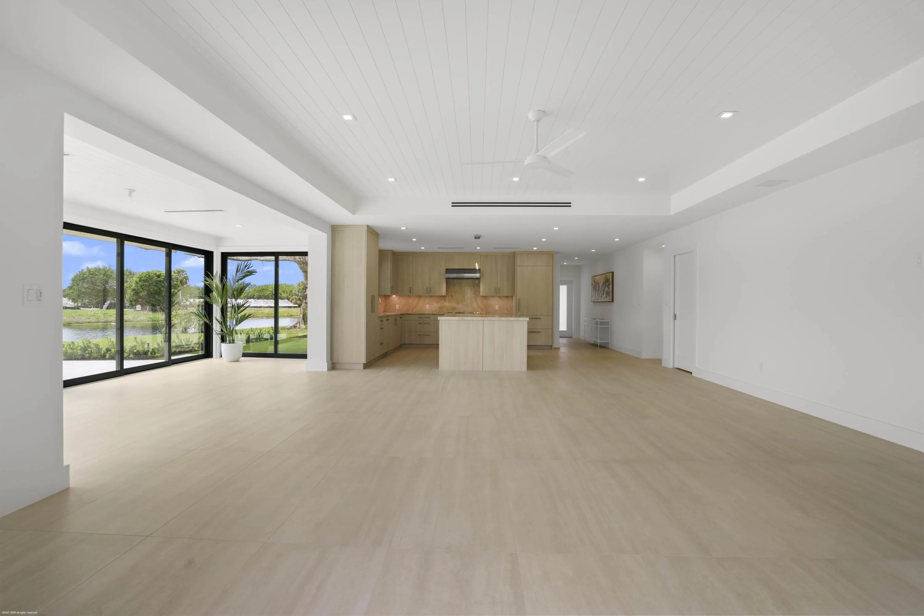 Expansive open-concept living area with light wood-finish flooring, a white shiplap ceiling, and recessed lighting
